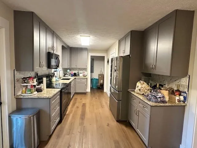 a kitchen with refrigerator and wooden cabinets
