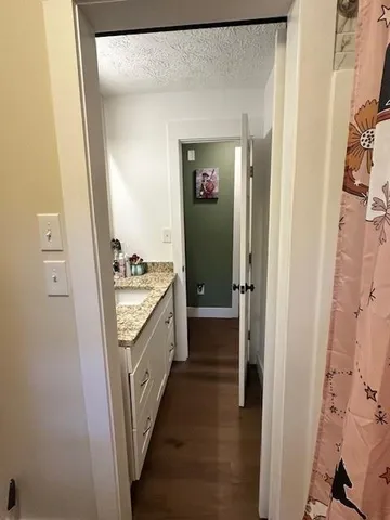 a bathroom with a granite countertop sink a mirror and a shower
