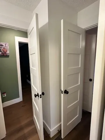a view of a hallway with wooden floor and stairs