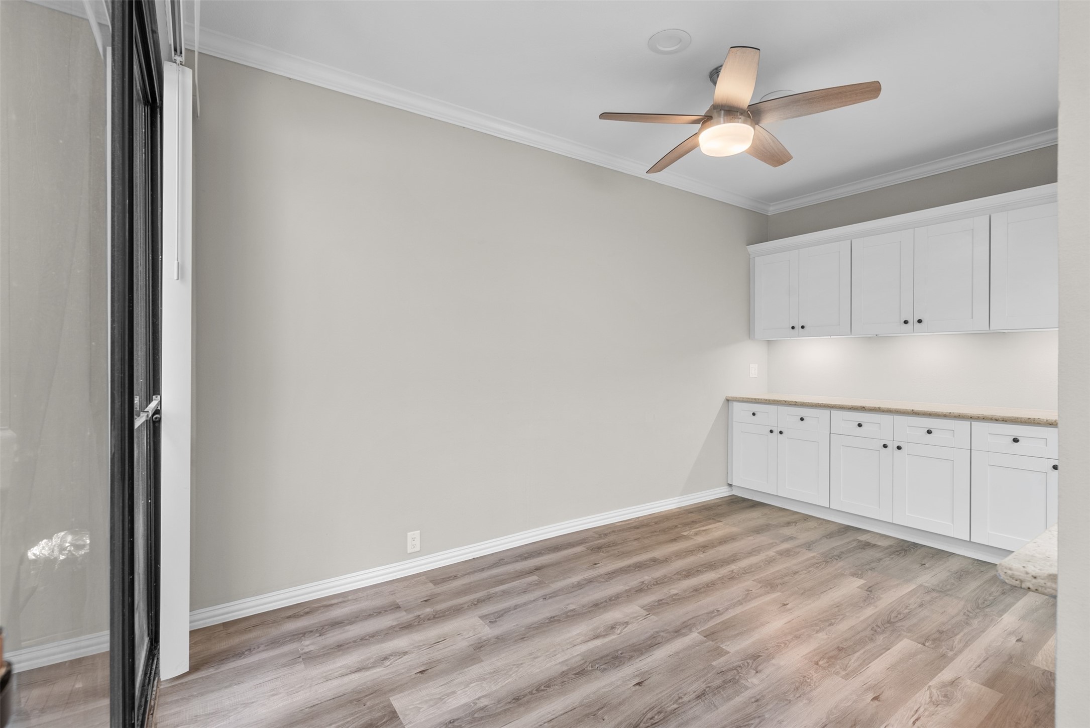 161 Litchfield Lane Houston, TX 77024 - Photo 12 of 30 an empty room with a ceiling fan and wooden floor