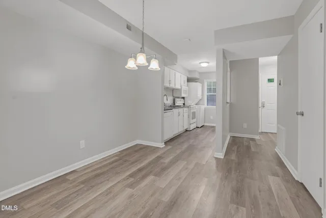 a view of a kitchen with wooden floor a sink and dishwasher