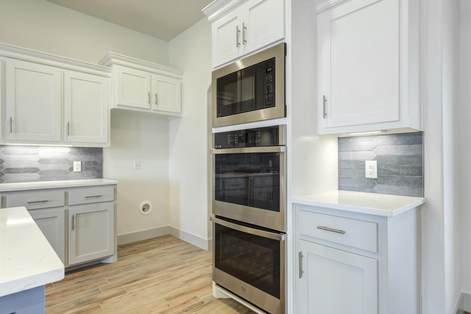 4608 140th Street Lubbock, TX 79424 - Photo 13 of 49 a kitchen with stainless steel appliances white cabinets and a stove a oven with wooden floor