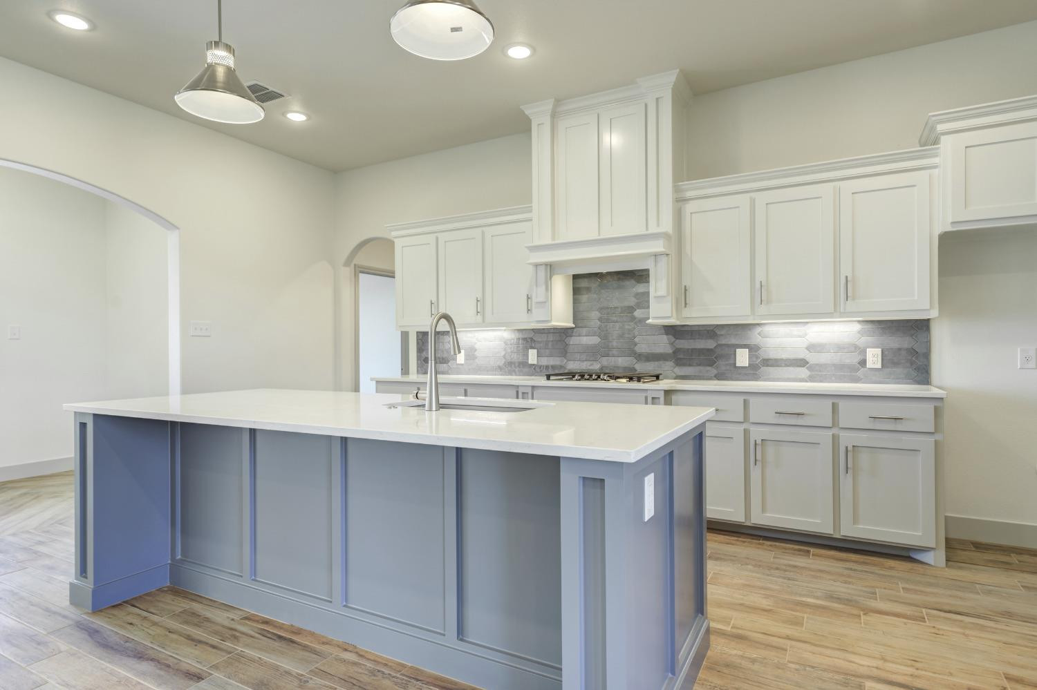 4608 140th Street Lubbock, TX 79424 - Photo 16 of 49 a kitchen with kitchen island granite countertop a sink cabinets and stainless steel appliances