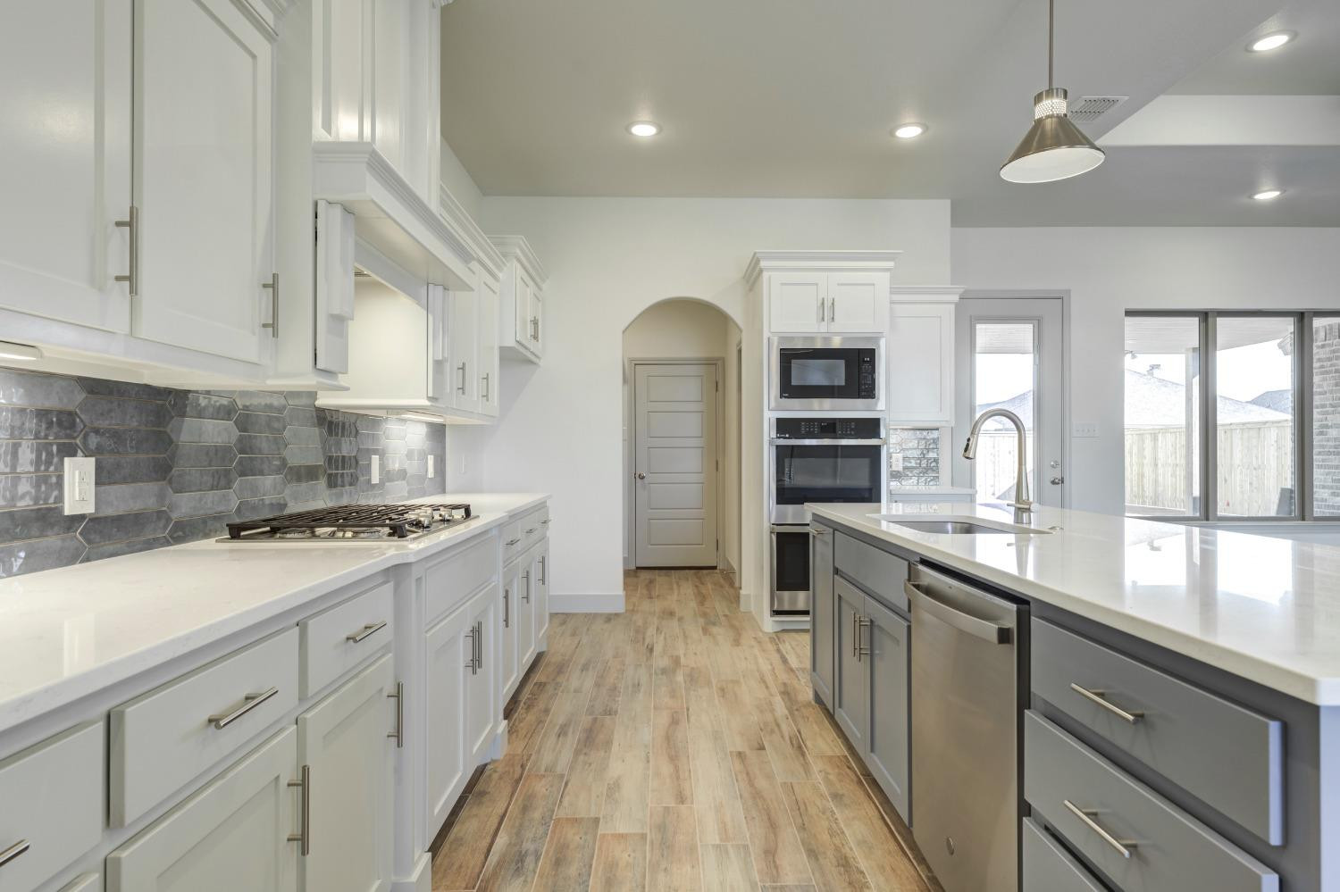 4608 140th Street Lubbock, TX 79424 - Photo 21 of 49 a large kitchen with stainless steel appliances granite countertop a lot of counter space and wooden floors