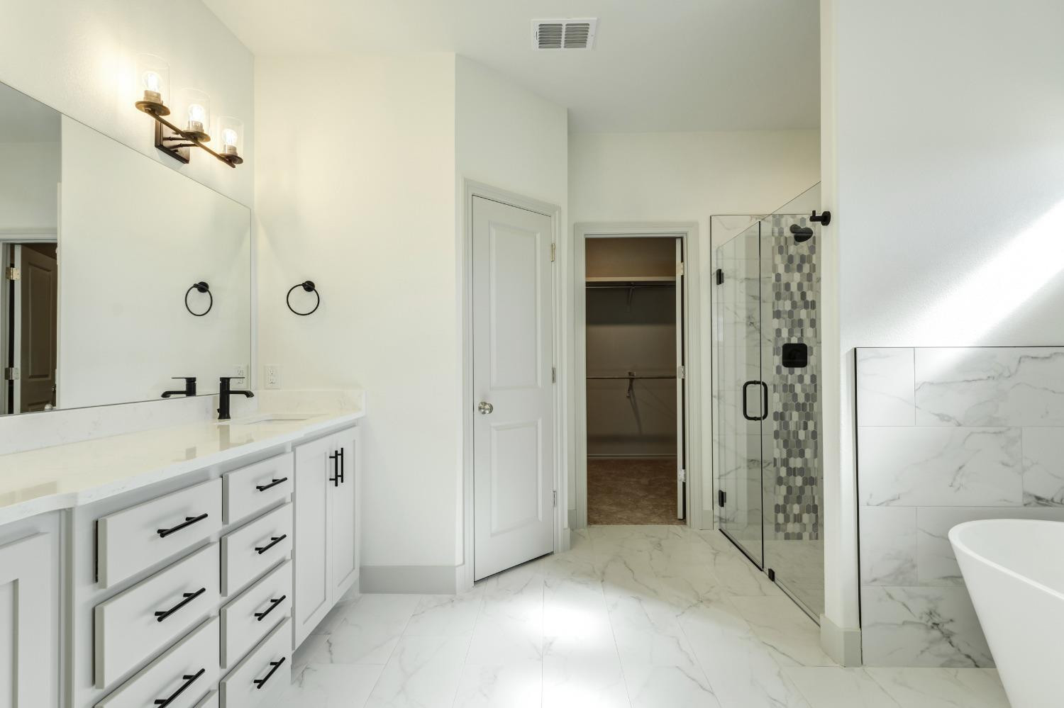 4608 140th Street Lubbock, TX 79424 - Photo 40 of 49 a spacious bathroom with a double vanity sink a toilet and shower