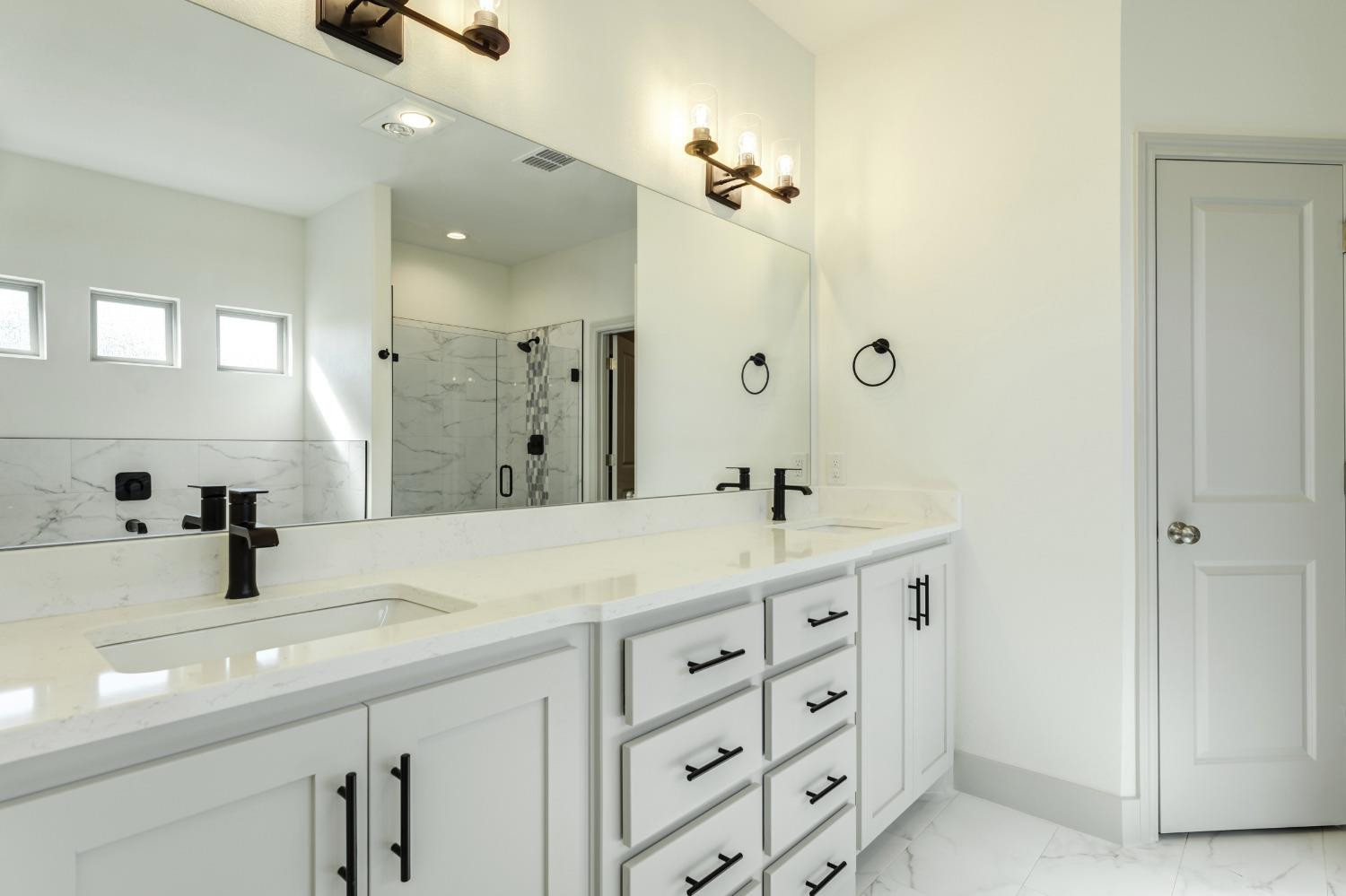 4608 140th Street Lubbock, TX 79424 - Photo 41 of 49 a bathroom with a sink double vanity granite tub shower and a mirror