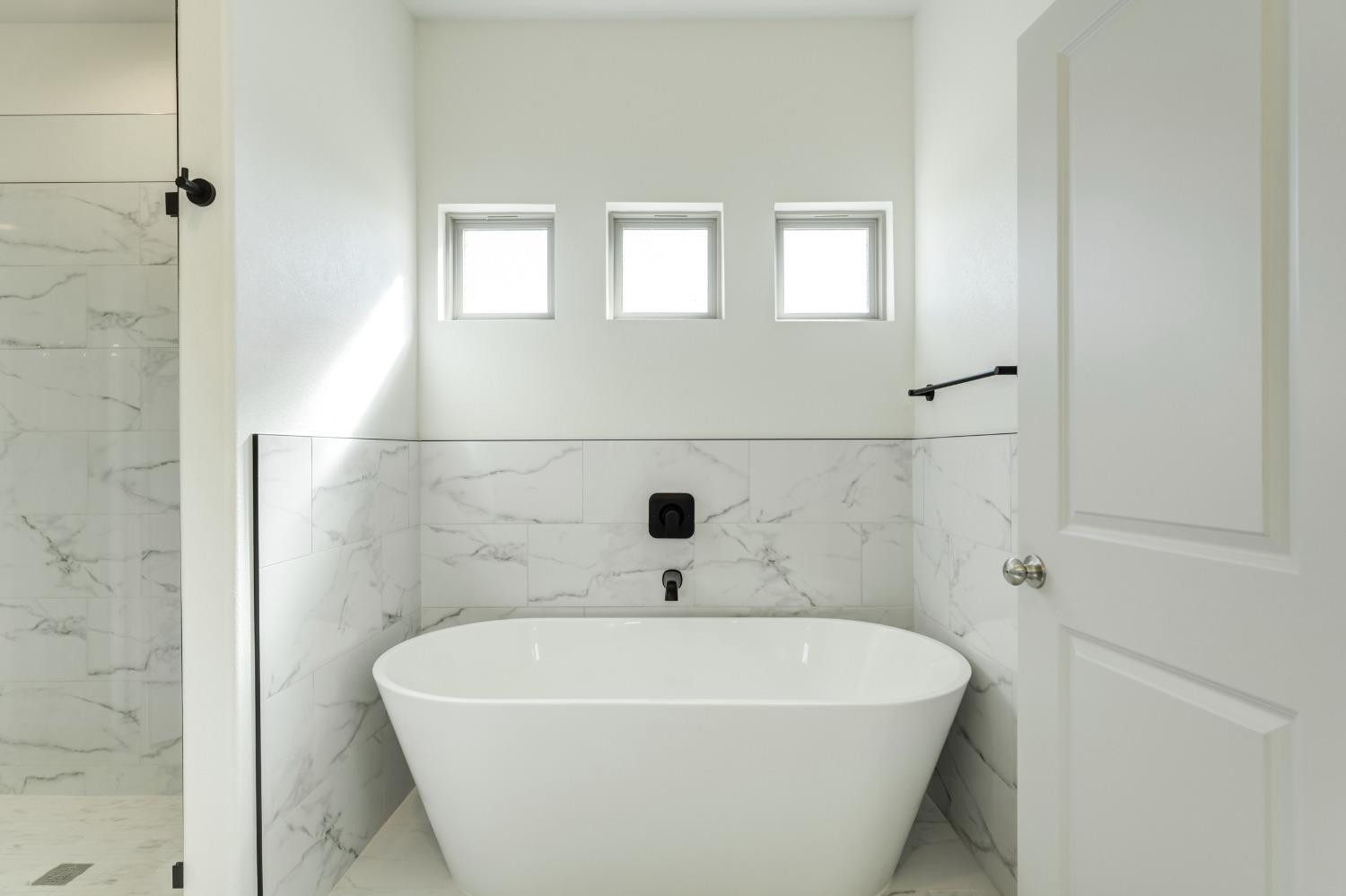 4608 140th Street Lubbock, TX 79424 - Photo 42 of 49 a white bath tub sitting in a bathroom