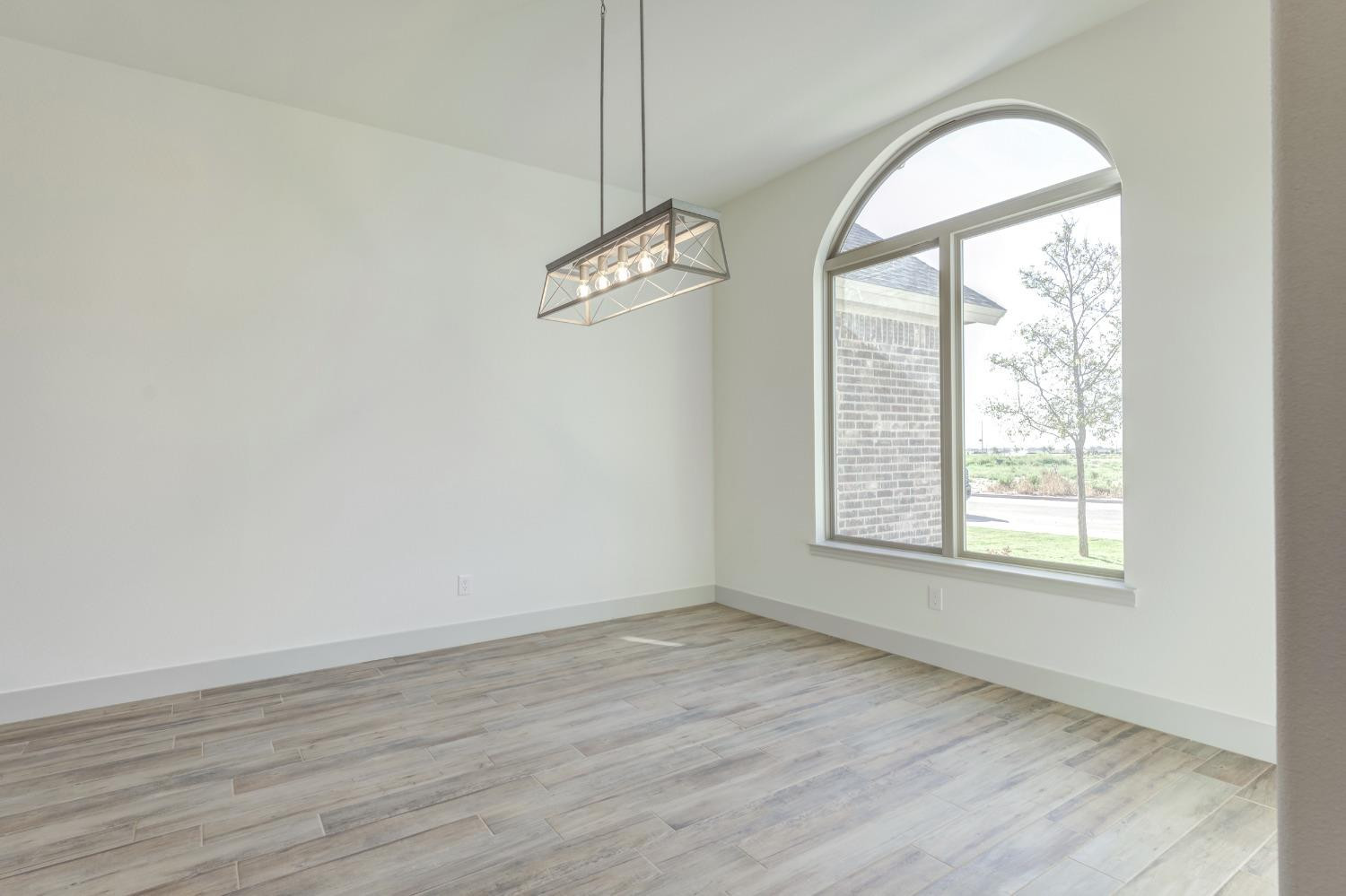 4608 140th Street Lubbock, TX 79424 - Photo 5 of 49 wooden floor in an empty room with a window