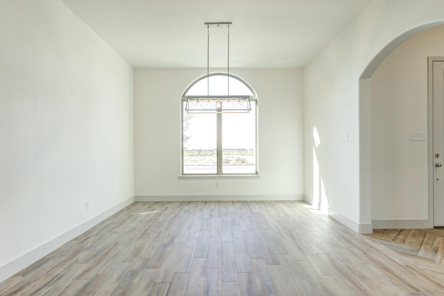 4608 140th Street Lubbock, TX 79424 - Photo 6 of 49 an empty room with wooden floor and windows