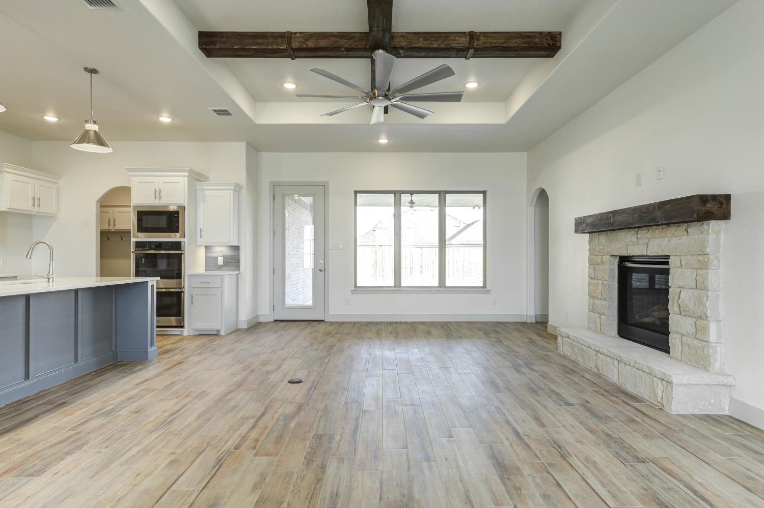 4608 140th Street Lubbock, TX 79424 - Photo 8 of 49 an empty room with wooden floor and a kitchen