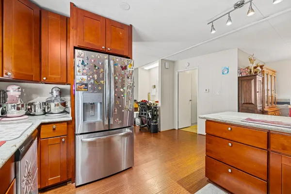 a kitchen with stainless steel appliances granite countertop a refrigerator and a stove top oven