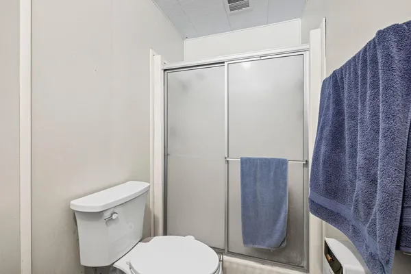 a white toilet sitting next to a wooden cabinet