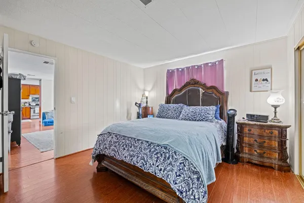 a bedroom with a bed and wooden floor
