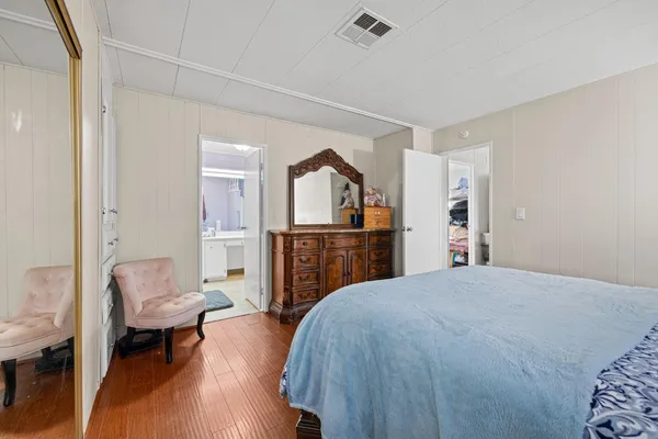 a spacious bedroom with a bed and a view of kitchen