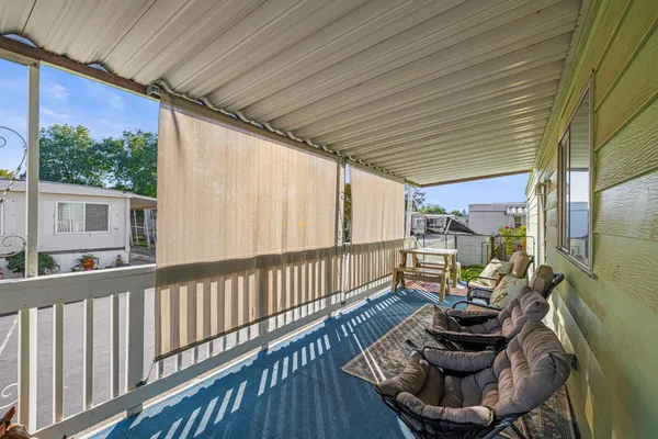 a balcony with chairs and with potted plants