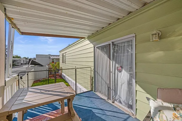a balcony with wooden floor table and chairs