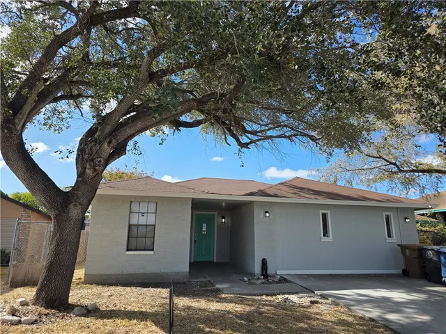 a front view of a house with a tree