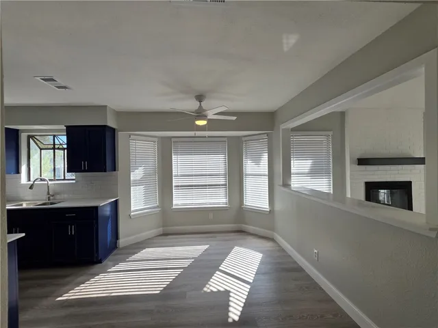 a view of an empty room with a fireplace and a window