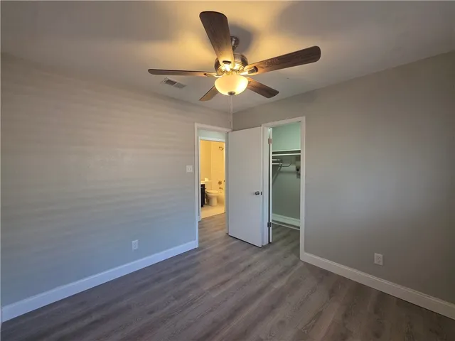 an empty room with closet and a chandelier fan