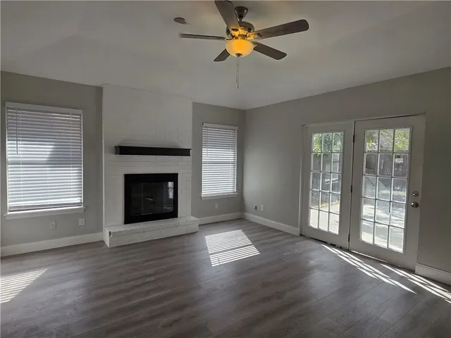 a view of empty room with fireplace and wooden floor