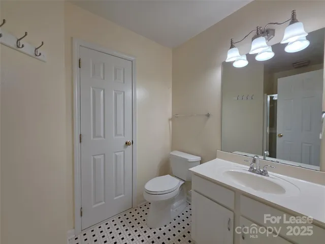 a bathroom with a toilet sink a mirror and vanity