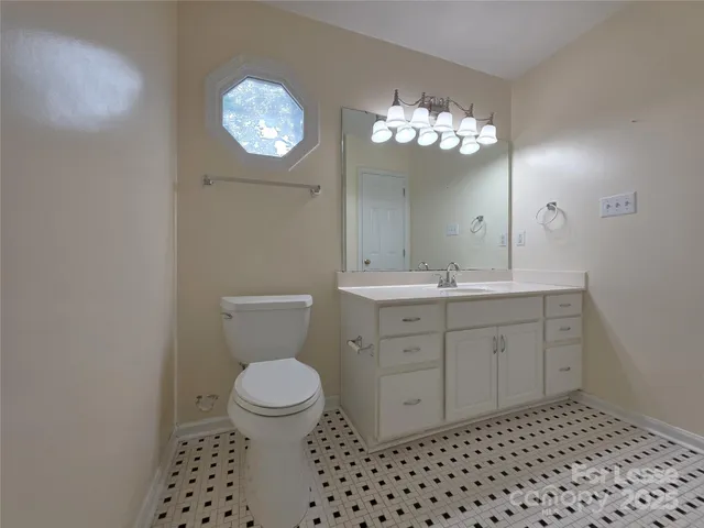 a bathroom with a sink a toilet a mirror and shower view