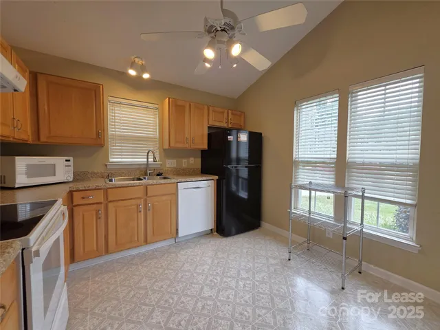 a kitchen with a refrigerator a sink and dishwasher with a large window