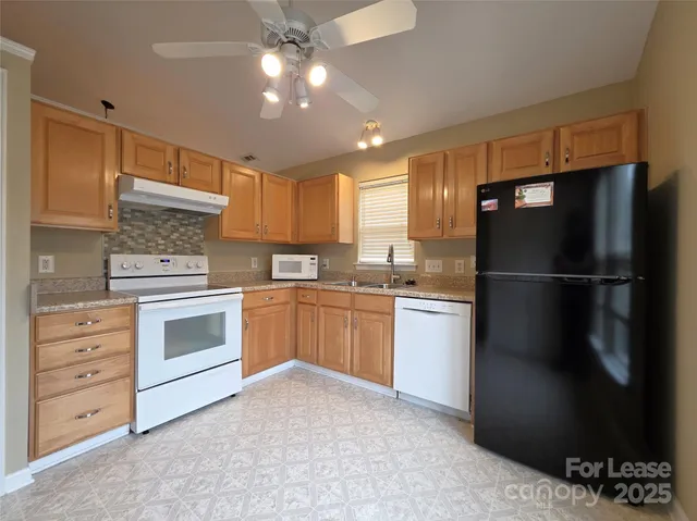 a kitchen with a refrigerator stove and cabinets