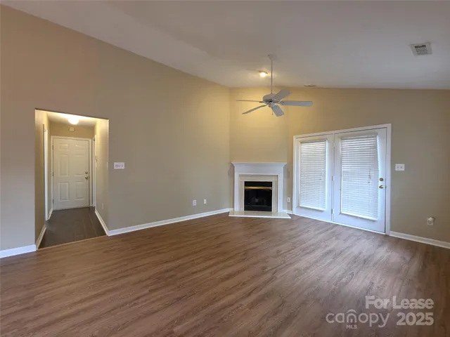 a view of empty room with wooden floor and fireplace