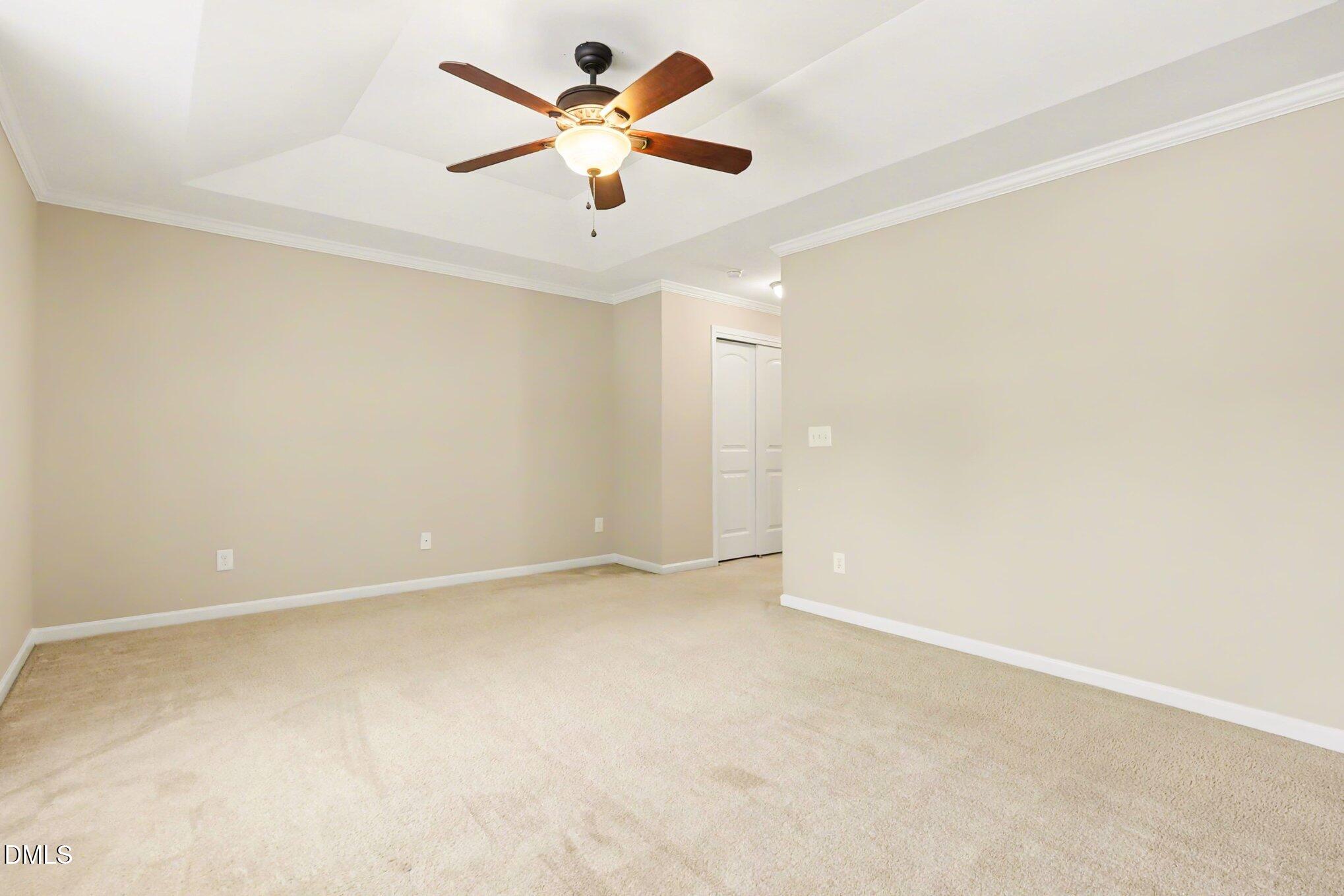 2409 Memory Ridge Drive Raleigh, NC 27606 - Photo 17 of 36 an empty room with a chandelier fan and windows