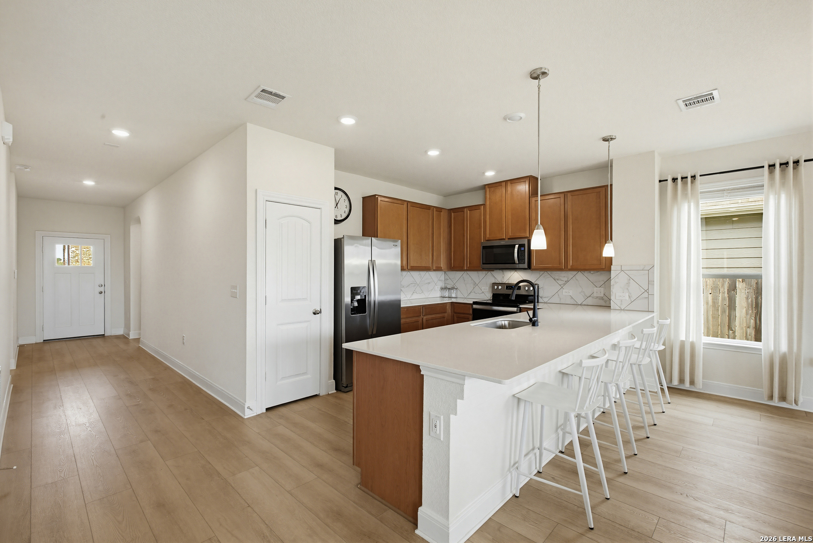 7829 Big Wind Way Austin, TX 78724 - Photo 10 of 26 a large kitchen with stainless steel appliances kitchen island a large counter top and wooden floors