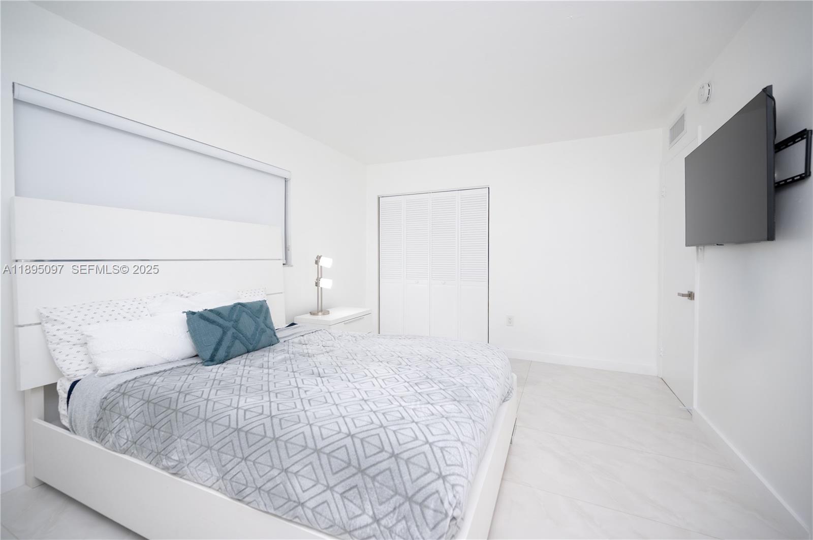 10875 Southwest 112th Avenue, Unit 204 Miami, FL 33176 - Photo 19 of 27 a bedroom with a bed and a flat screen tv