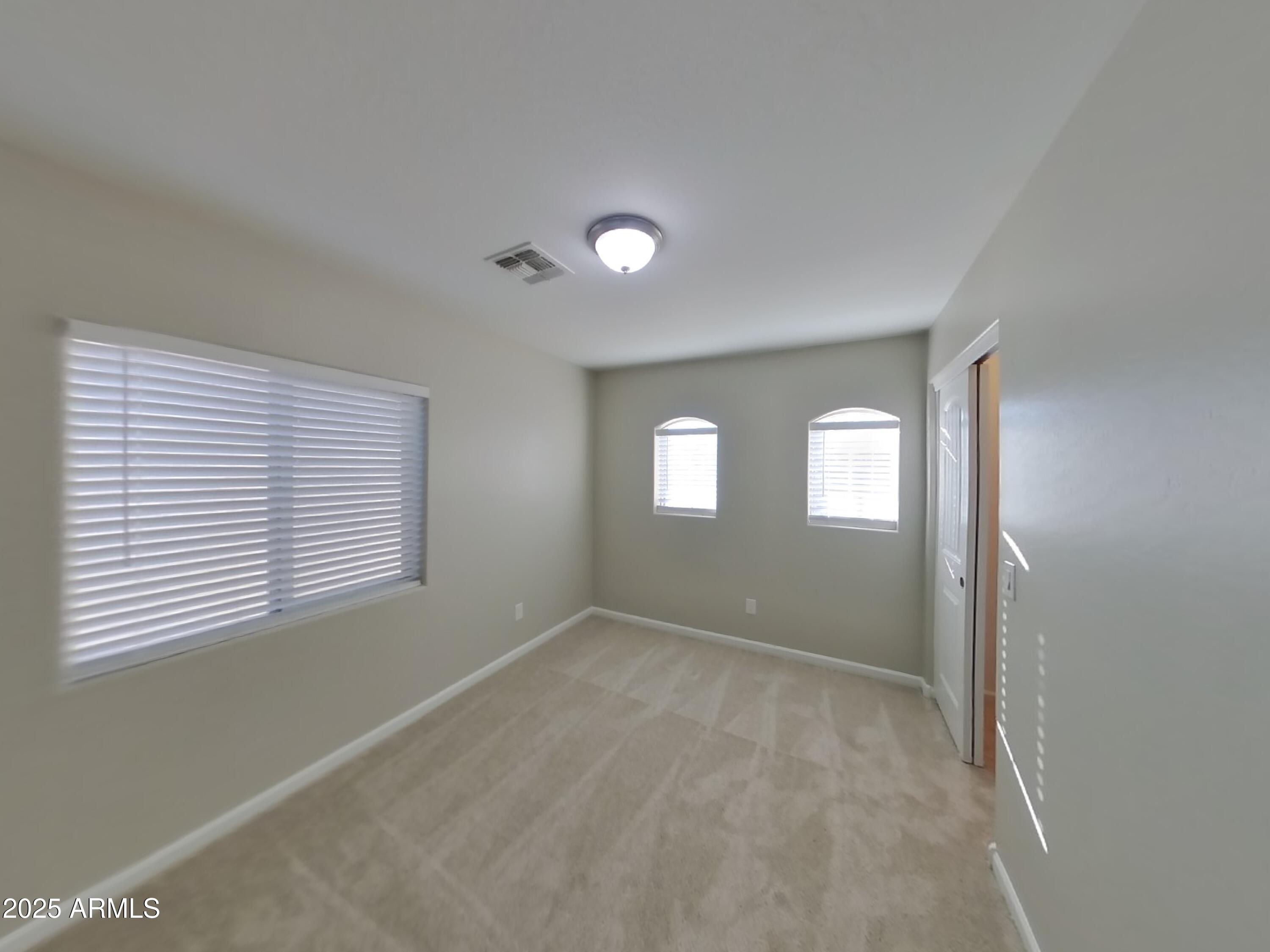 10336 West Devonshire Avenue Phoenix, AZ 85037 - Photo 10 of 18 a view of an empty room with a window and wooden floor