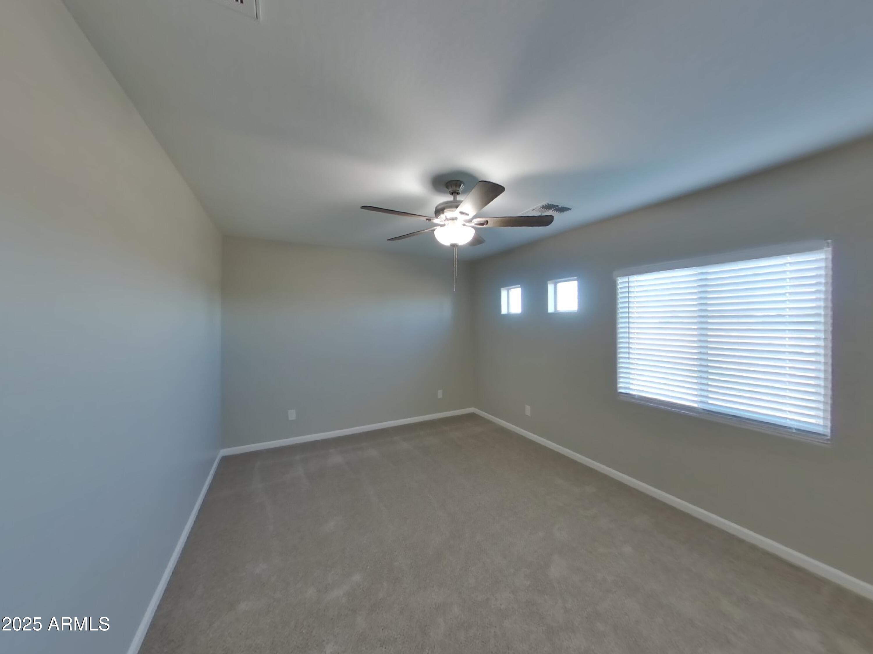 10336 West Devonshire Avenue Phoenix, AZ 85037 - Photo 14 of 18 an empty room with a window and a fan