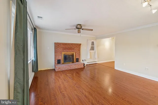 a view of a bedroom with wooden floor and a window