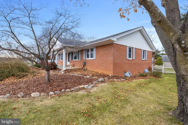 a backyard of a house with large trees and brick walls