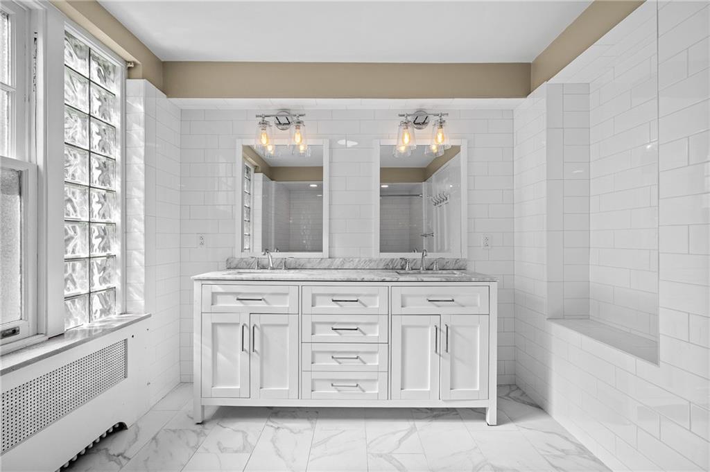 115 Woodland Road Pittsburgh, PA 15232 - Photo 36 of 50 a bathroom with a double vanity sink a mirror and a bathtub