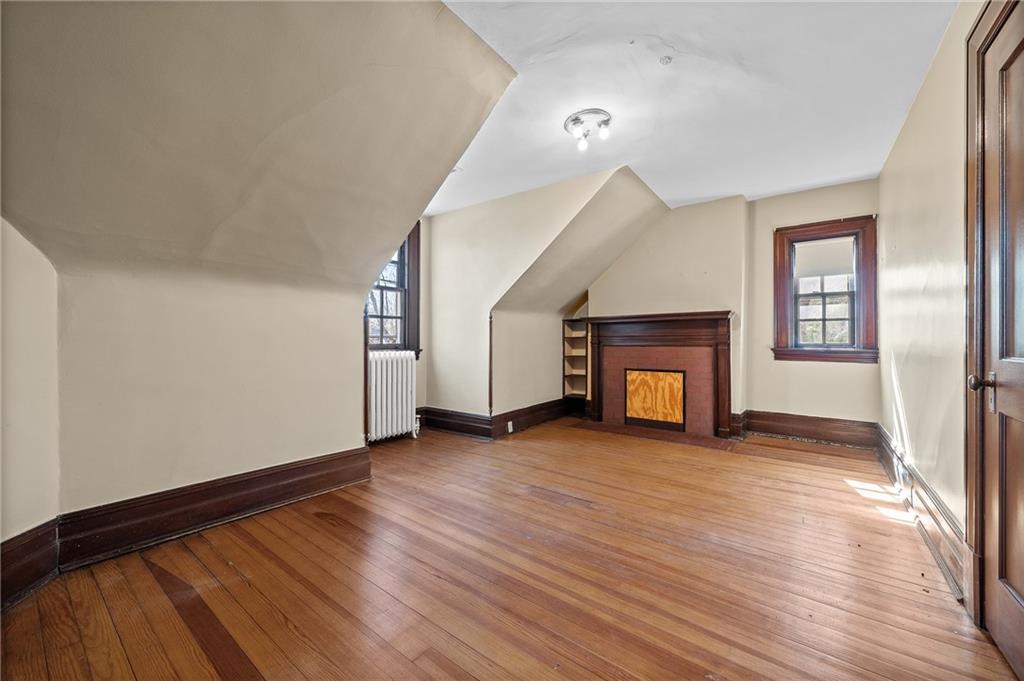 115 Woodland Road Pittsburgh, PA 15232 - Photo 44 of 50 a view of an empty room with wooden floor fireplace and a window