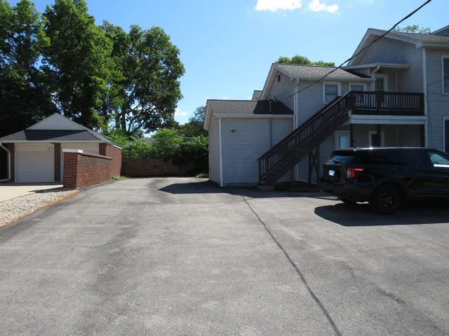 a view of a house with a wooden bench