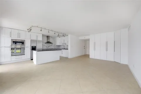 a view of kitchen with kitchen island white cabinets and stainless steel appliances