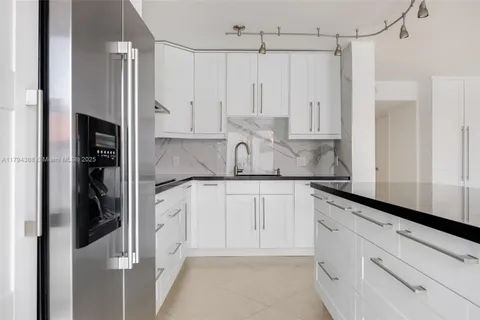 a kitchen with stainless steel appliances granite countertop a refrigerator and a sink