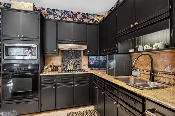 a kitchen with stainless steel appliances granite countertop a refrigerator and a stove