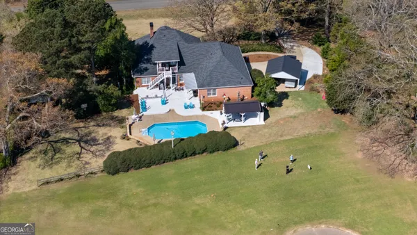 an aerial view of a house with a yard basket ball court and outdoor seating