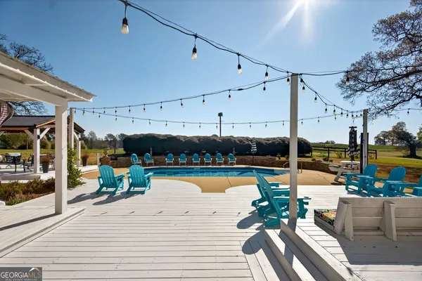 a view of a patio with dining table and chairs with wooden floor and fence