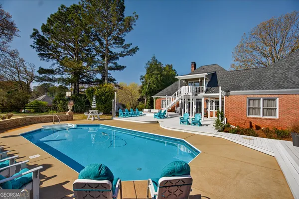 an aerial view of a house with swimming pool and porch