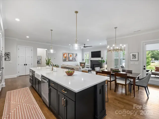 a view of a dining room and livingroom with furniture wooden floor a chandelier