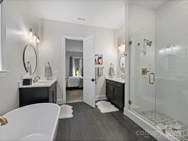 a en suite bathroom with a double vanity sink a toilet a mirror and shower