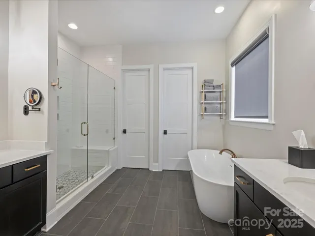 a spacious bathroom with a tub shower and sink