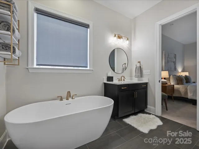 a bathroom with a tub a double vanity sink and a mirror