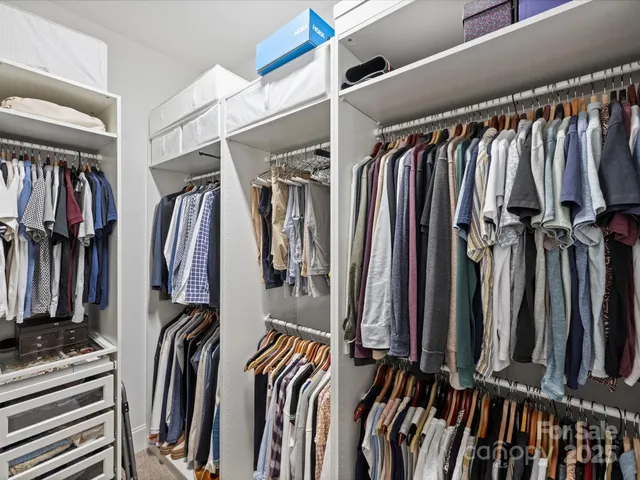 a view of walk in closet with clothes and shoes